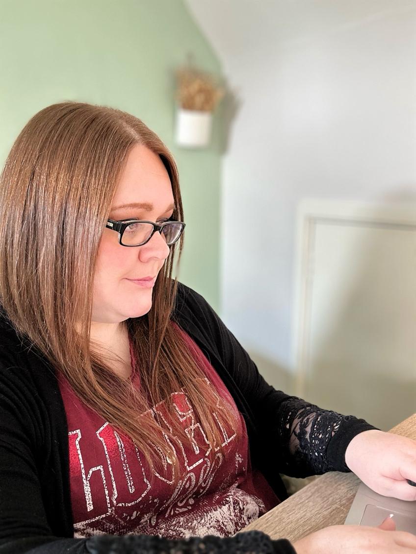 Sarah typing on a laptop